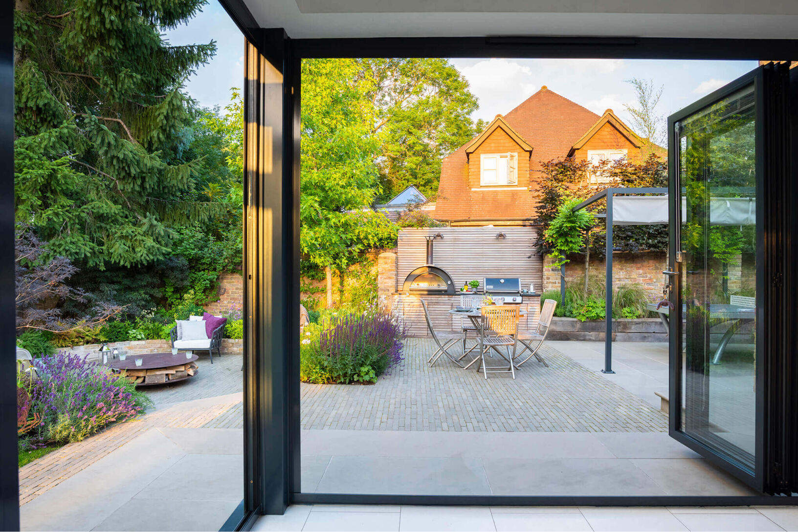 view from in side the house out through large glass doors to the garden space